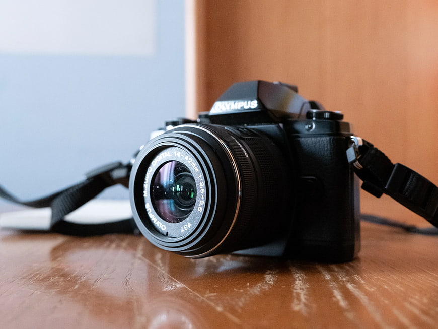 Black Olympus Camera on Wooden Desk