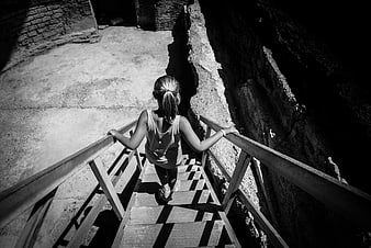 Woman walking down wooden stairs in black and white