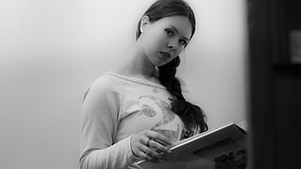 Black and white portrait of young woman reading book