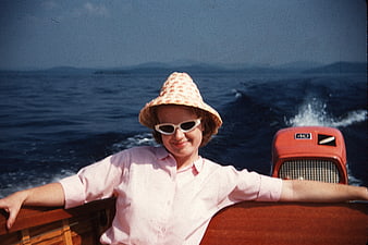 Vintage woman in hat and sunglasses on a boat
