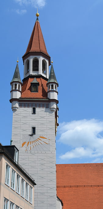 Historic Church Tower with Red Roof and Blue Sky