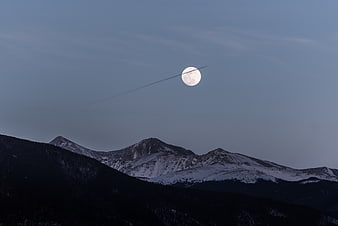 Full Moon Over Snowy Mountain Peaks at Dusk