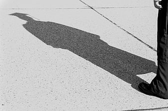 Black and white shadow of graduate on pavement