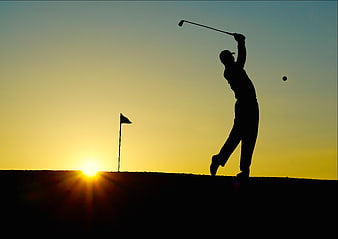 Silhouette of Golfer Swinging at Sunset