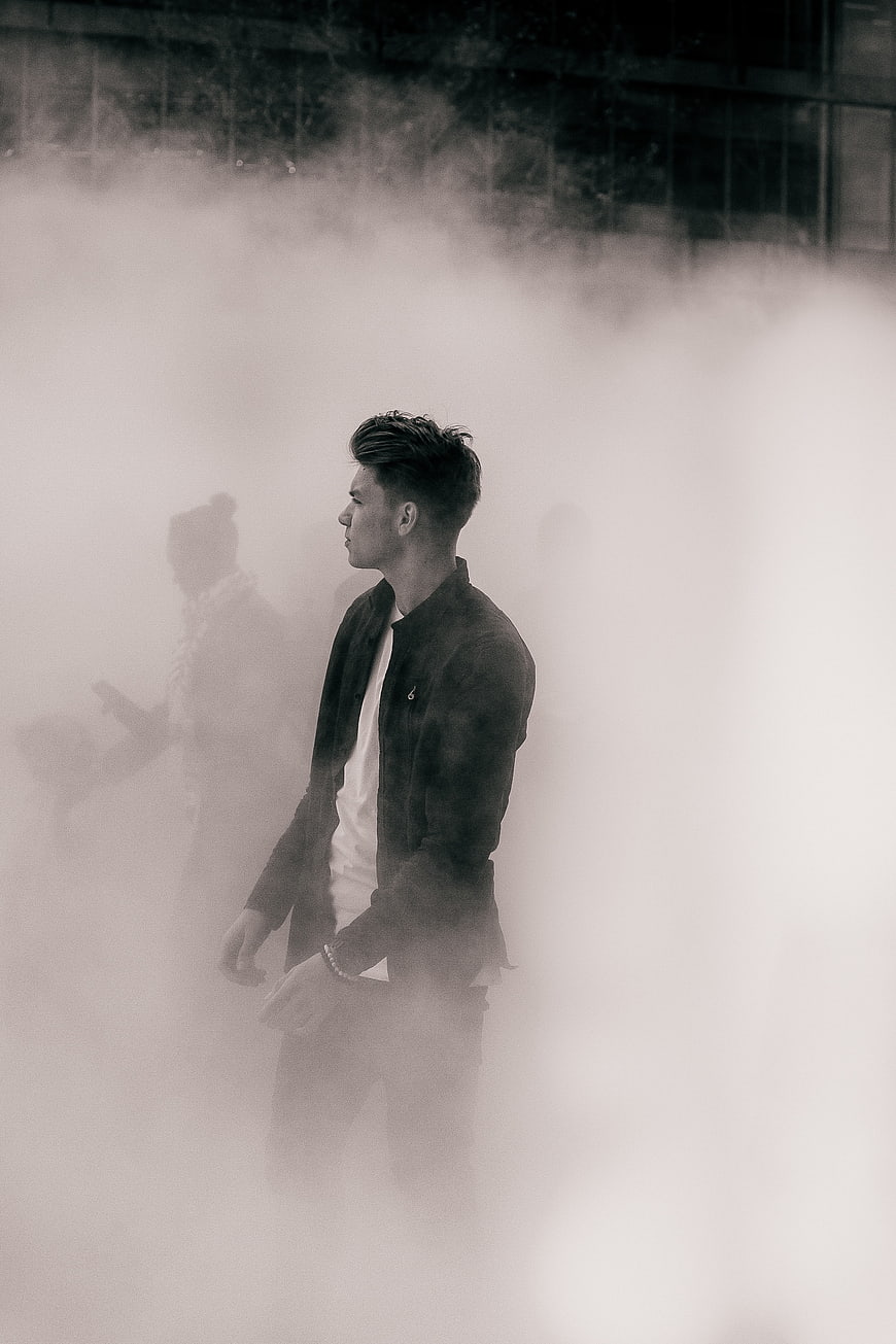 Man in Jacket Standing in Thick Fog