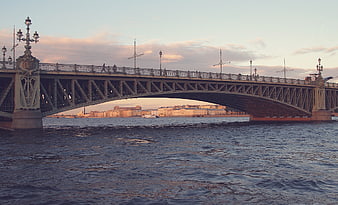 Iron Bridge Over River at Sunset with City Skyline