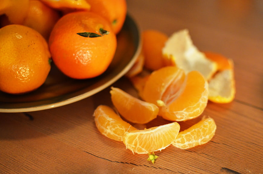 Fresh peeled mandarin orange segments on wooden table