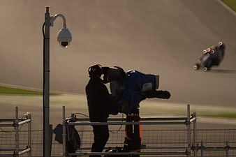 Cameraman filming motorcycle race on track