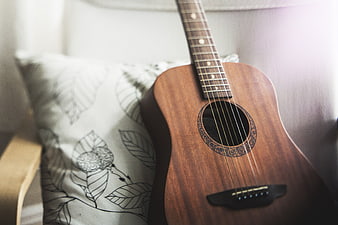 Acoustic Guitar on Chair with Leaf Pattern Pillow