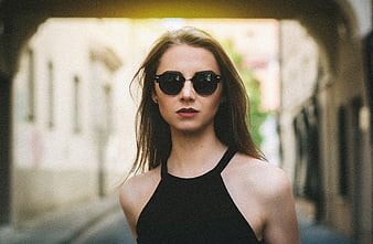 Young woman wearing sunglasses in a European alleyway
