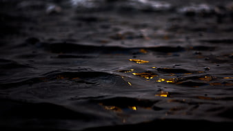 Dark ocean water with golden sunset reflections