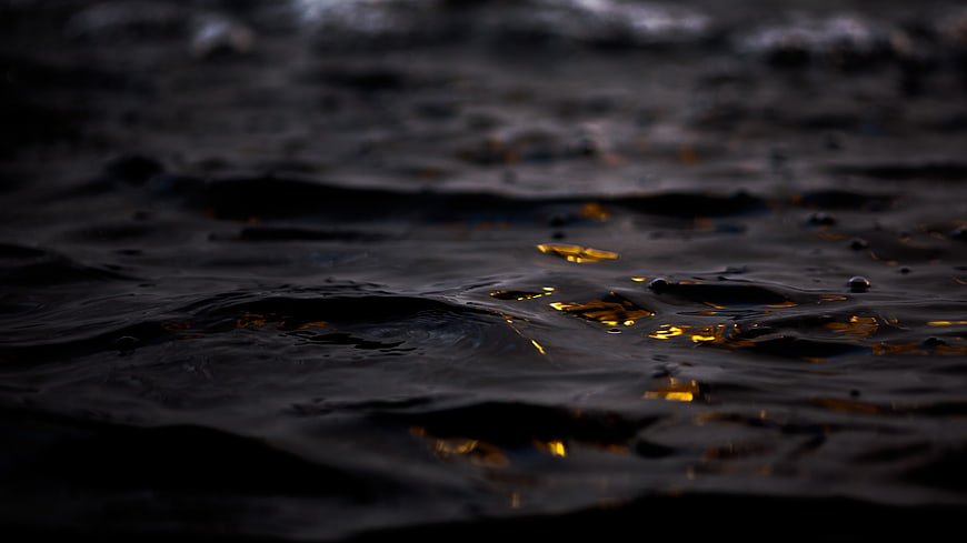 Dark ocean water with golden sunset reflections