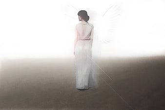 Woman with angel wings standing in bright light