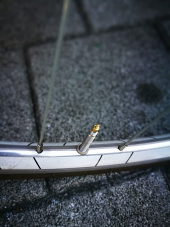 Close-up of bicycle wheel rim with brass Presta valve