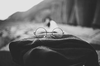 Black and white round eyeglasses on a textured fabric surface