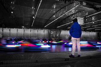 Man Watching Bumper Cars with Motion Blur at Night
