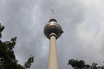 Berlin TV Tower against cloudy sky with tree branches