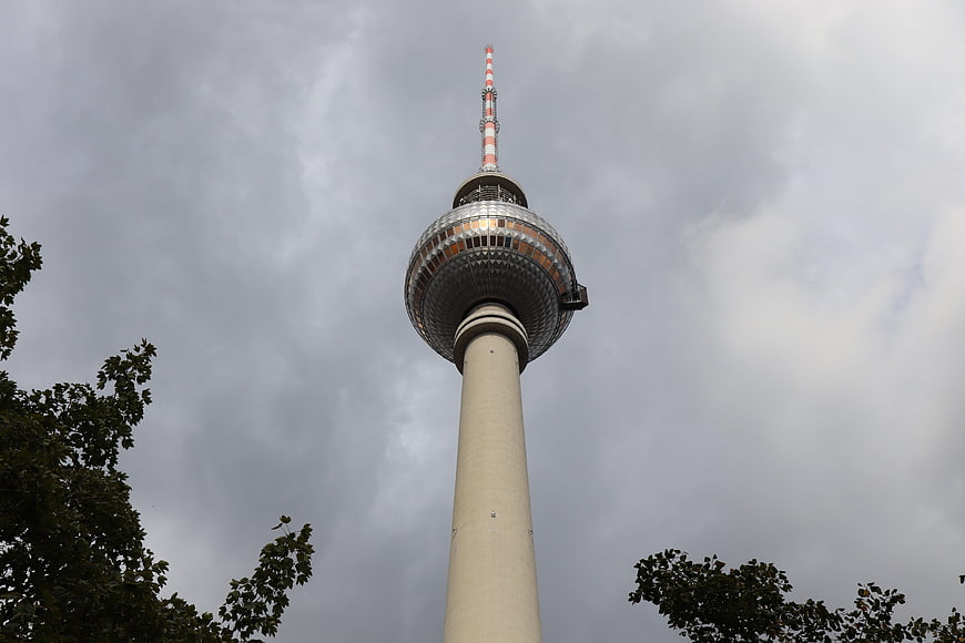 Berlin TV Tower against cloudy sky with tree branches
