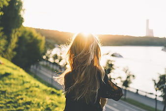 Woman with Blonde Hair Looking at Sunset Over River