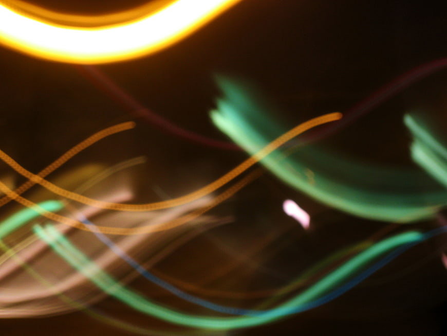 Abstract colorful light trails and swirls on dark background