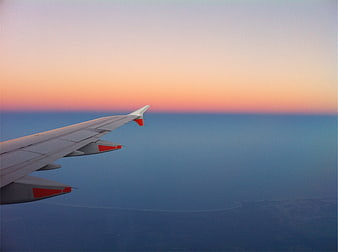 Airplane Wing Over Ocean at Sunset