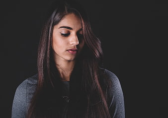 Portrait of a woman with eyes closed against a dark background