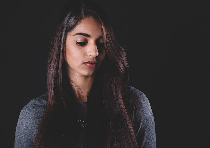 Portrait of a woman with eyes closed against a dark background