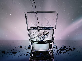 Diamond in glass of water with splash and light effects