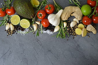 Fresh Avocado, Tomatoes, Garlic, and Herbs on Slate Background