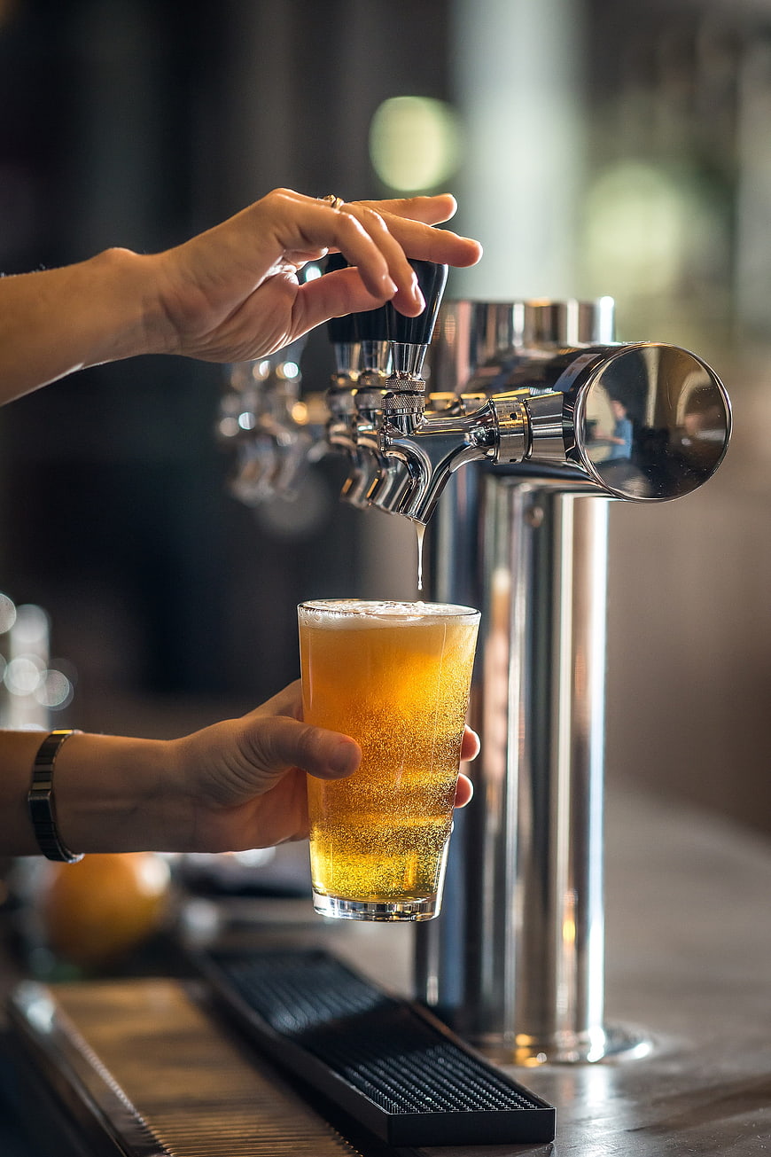Pouring Draft Beer from Tap into Glass at Bar