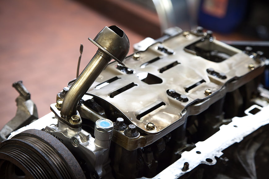 Close-up of disassembled car engine valve cover and pulley