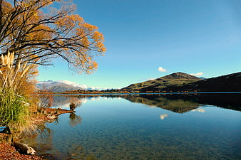 Serene Autumn Lake Landscape with Golden Trees and Mountain Reflections
