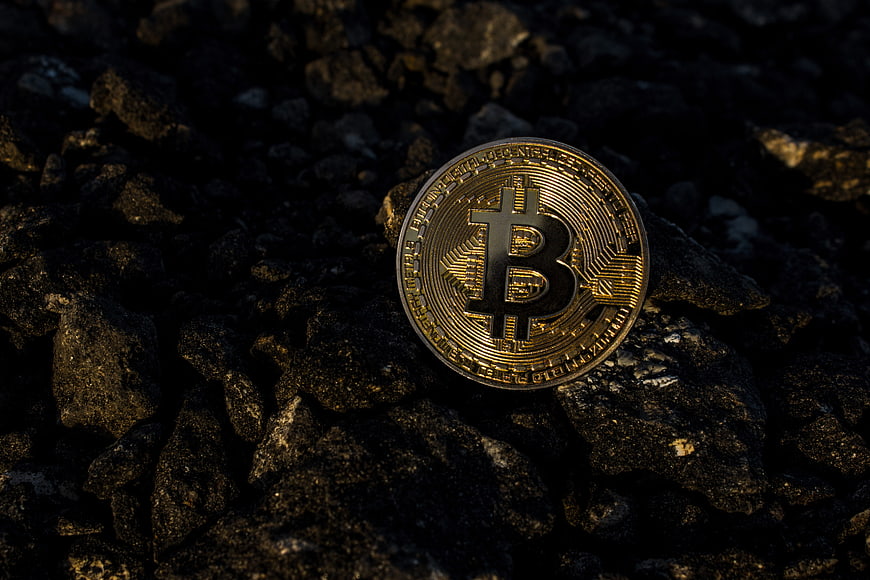 Gold Bitcoin on Dark Rocks