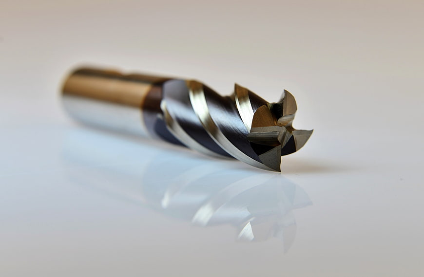 Close-up of a CNC milling cutter end mill on a white surface