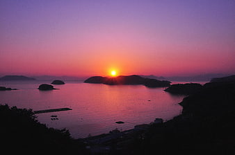 Vibrant purple and pink sunset over coastal islands