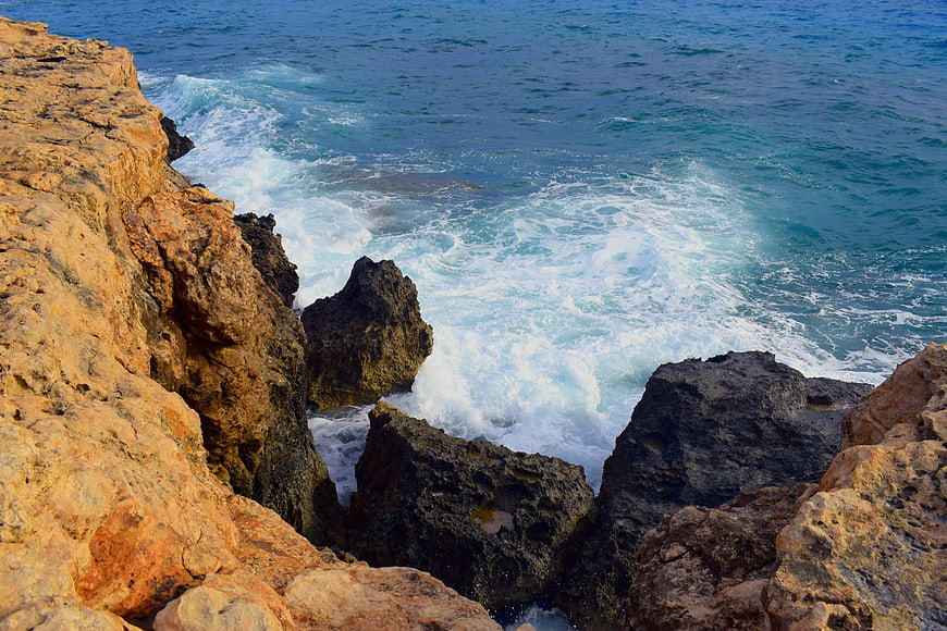 Rugged Rocky Coastline with Crashing Waves and Blue Sea