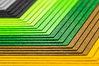 Close-up of stacked colorful paper sheets in green, yellow, and brown