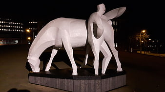 White geometric horse sculpture illuminated at night