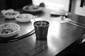 Stainless steel cup on wooden table with side dishes