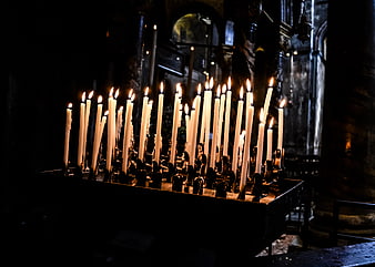 Lit prayer candles in dark church interior