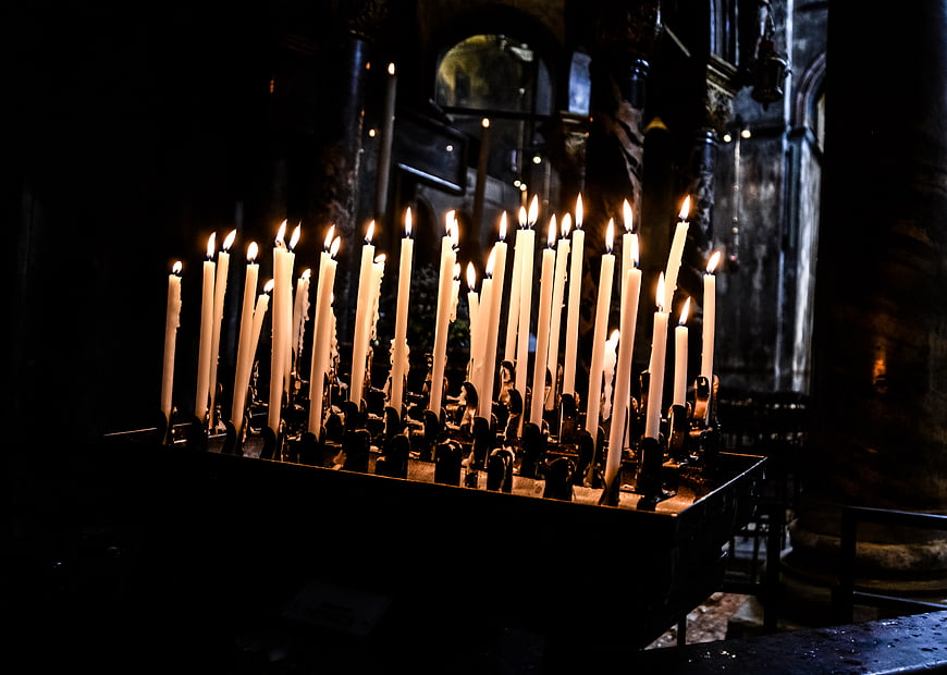 Lit prayer candles in dark church interior