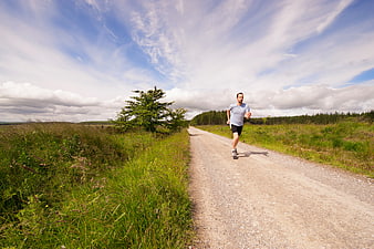 Man jogging on gravel road in nature