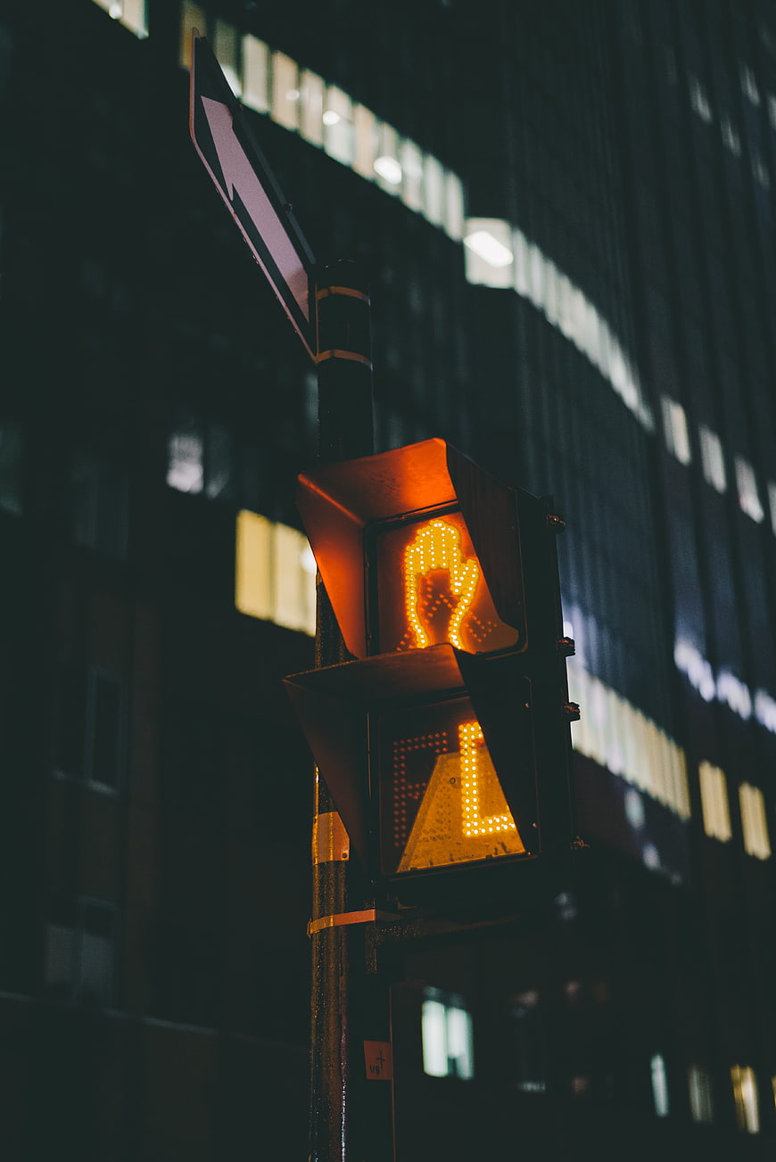 Glowing Orange Pedestrian Traffic Light at Night in City
