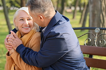 Happy Senior Couple Embracing on Park Bench