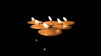 Floating Tea Light Candles on Black Water Surface