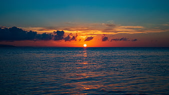 Vibrant Ocean Sunset with Dramatic Clouds and Sun Reflection