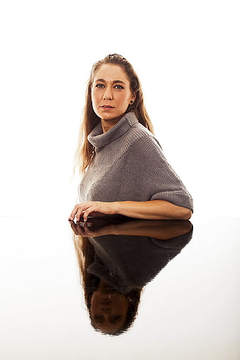 Professional young woman in gray turtleneck sweater with reflection on white background