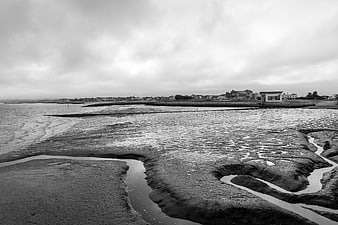 Black and White Coastal Landscape with Sand Ripples and Overcast Sky