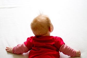 Baby Crawling On White Bed Sheet Wearing Red Outfit
