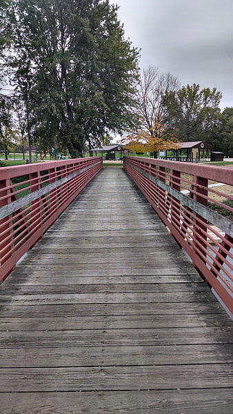 Red wooden pedestrian bridge in park